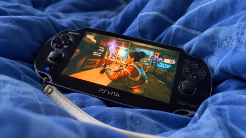 PS Vita OLED posée sur une couette bleue, avec Cyberpunk 2077 affiché à l’écran.